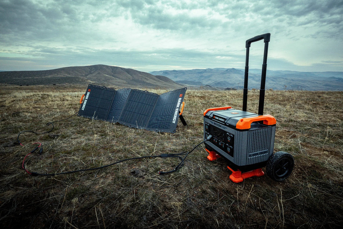 Portable power station with solar panel in a field under a cloudy sky