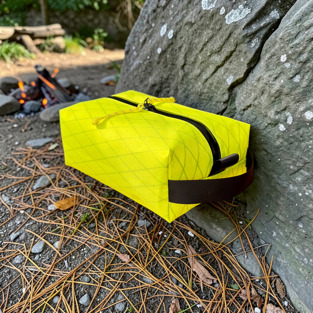 Yellow bag with black zipper against a stone wall outdoors