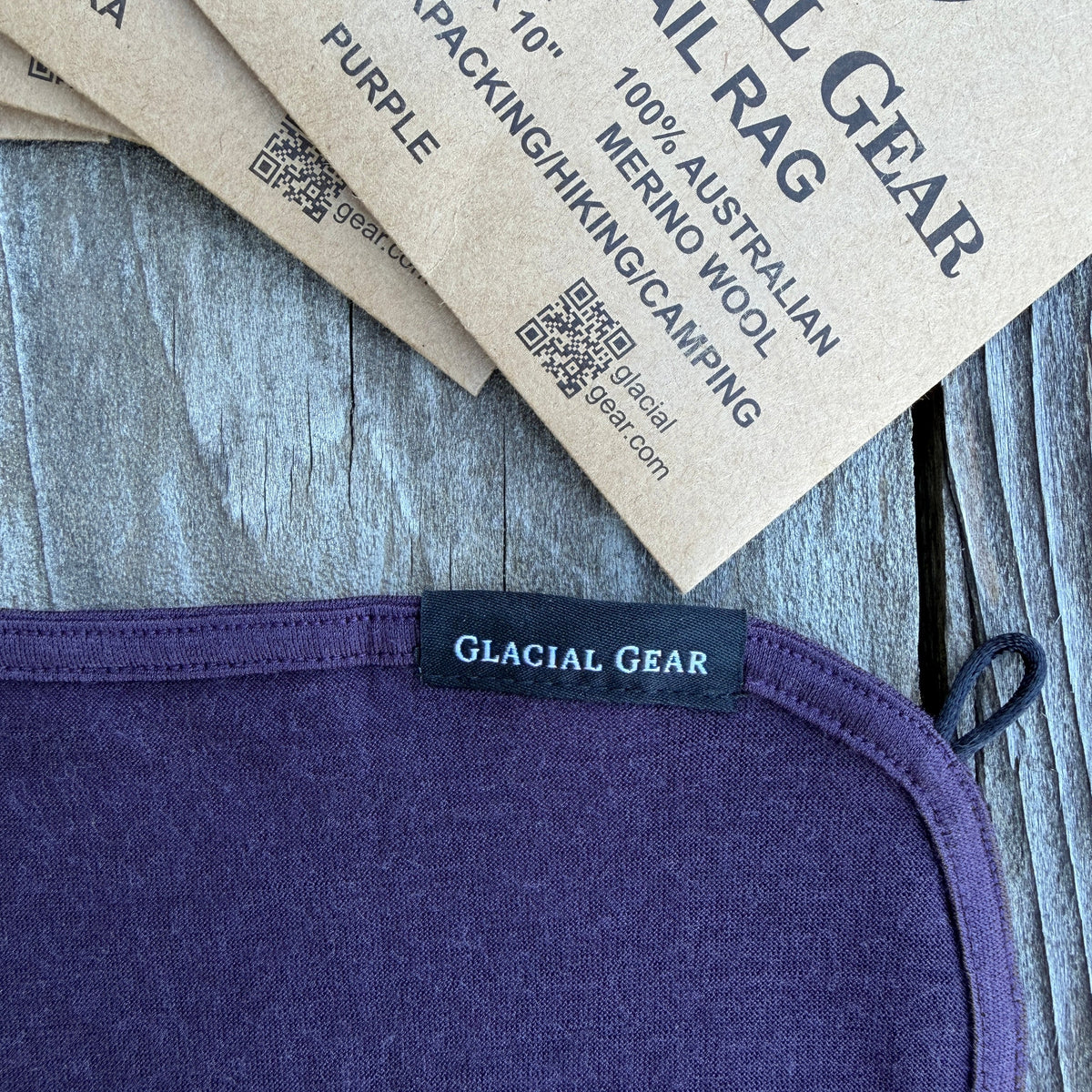 Purple merino wool tail rag with Glacial Gear label on a wooden surface