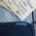 Navy blue merino wool product with Glacial Gear label and packaging on a wooden surface