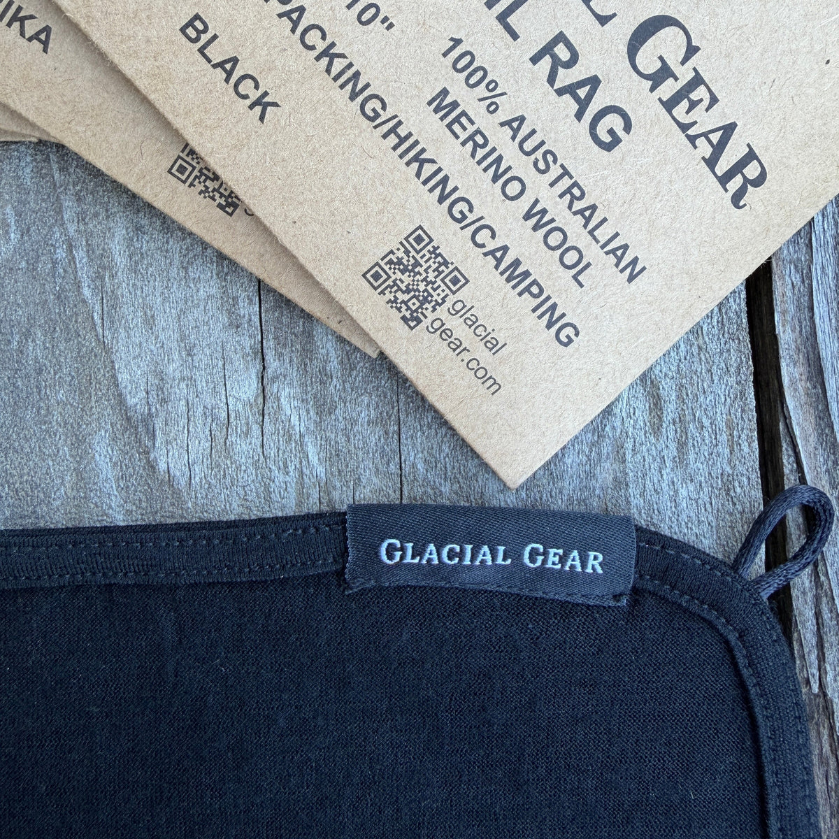 Navy blue merino wool product with Glacial Gear label and packaging on a wooden surface