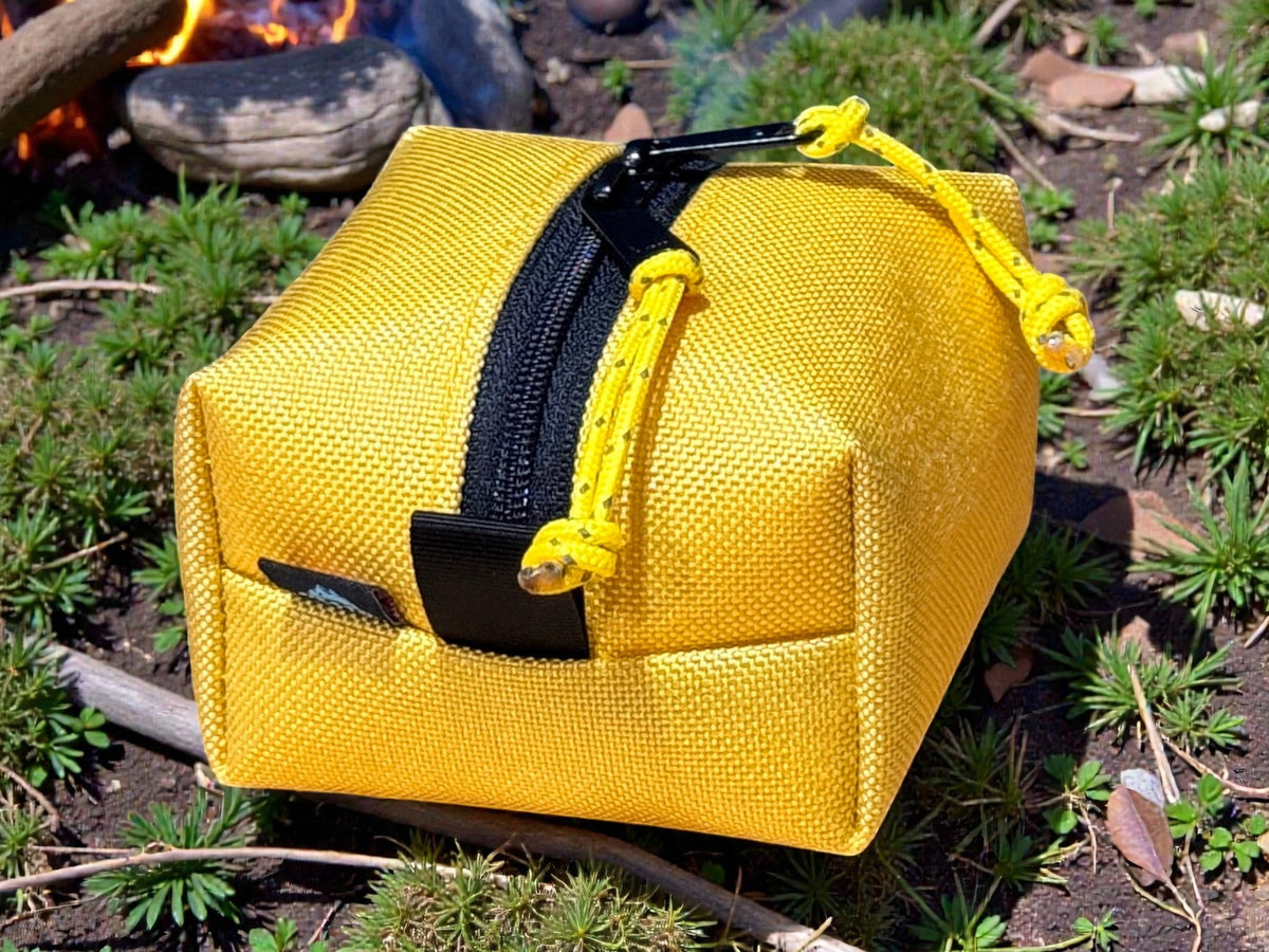 Yellow pouch with a black zipper on a natural background