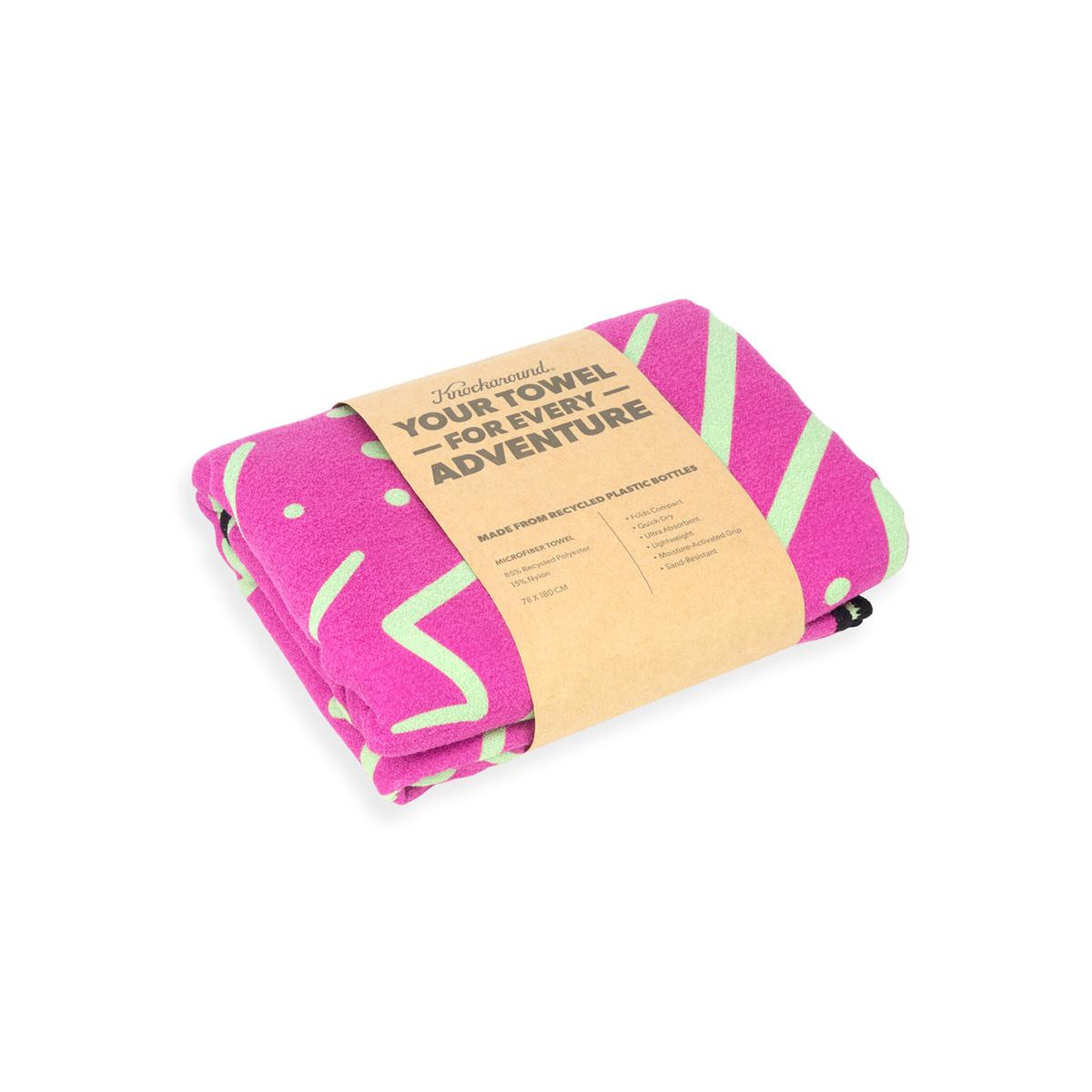 Pink towel with green patterns and a cardboard label on a white background