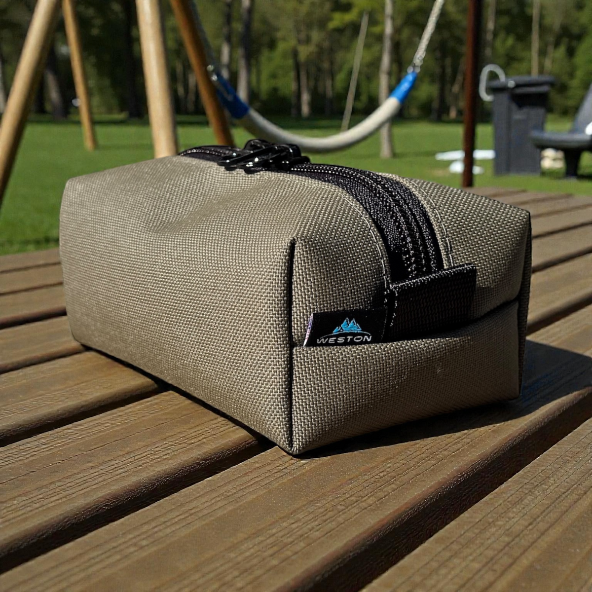 Beige toiletry bag with black zipper on a wooden surface, outdoor background