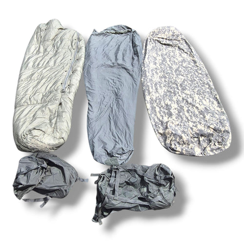 Five gray camping sleeping bag covers shown in various states of use, including packed and unpacked, on a white background with soft drop shadows.
