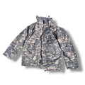 A digital camouflage utility jacket in a gray and beige pattern, shown flat against a white background with a drop shadow.