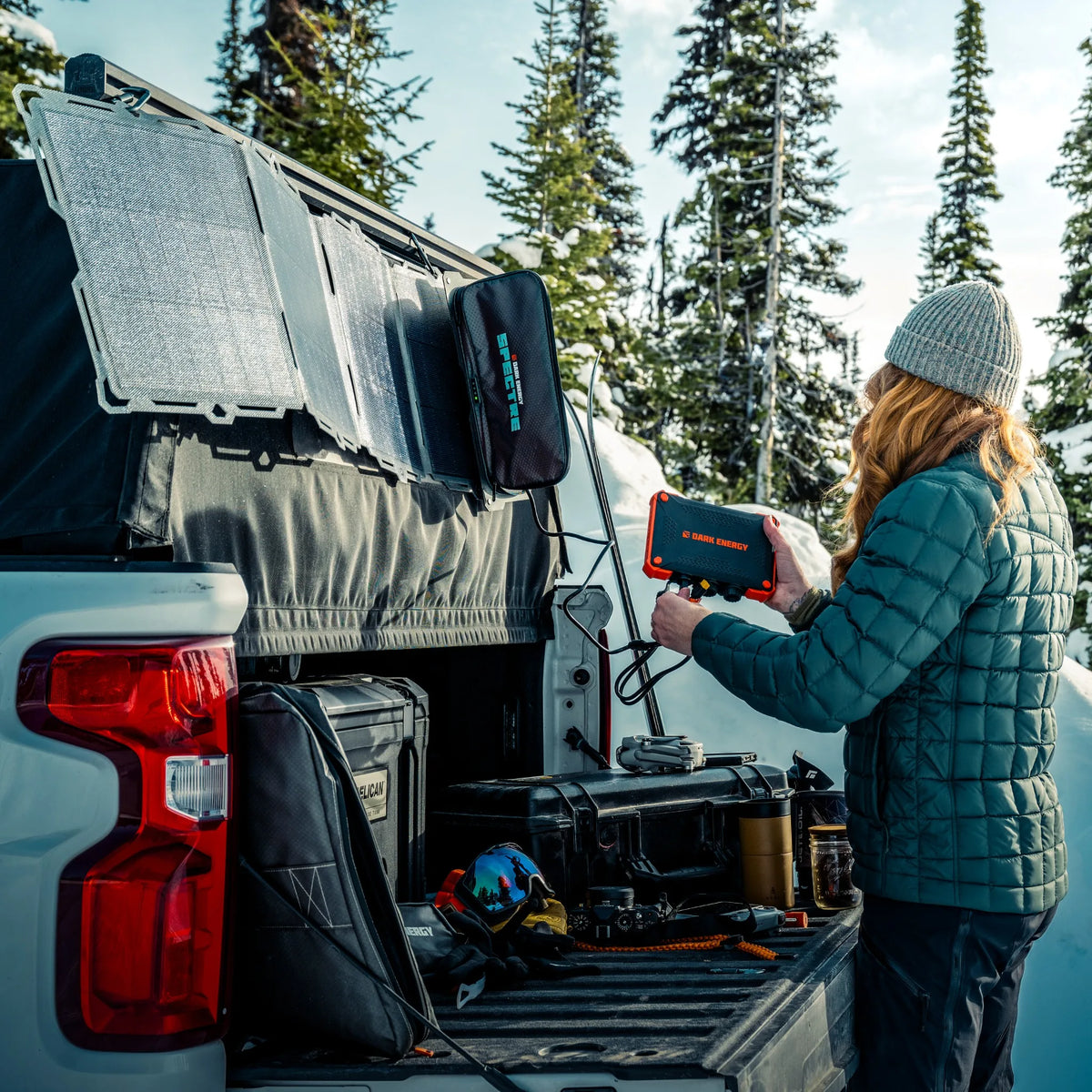 Person using a device in the back of a truck with trees in the background
